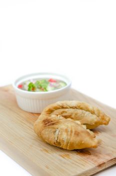 Curry puff pastry with sweet sauce  on wooden plate