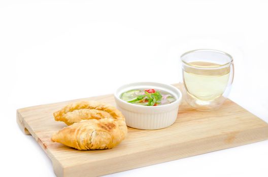 Curry puff pastry with sweet sauce  on wooden plate