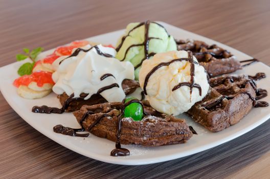 ice cream , chocolate waffles with chocolate sauce and whipping cream