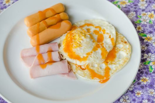 fried egg , ham , sausage with sauce on  dish