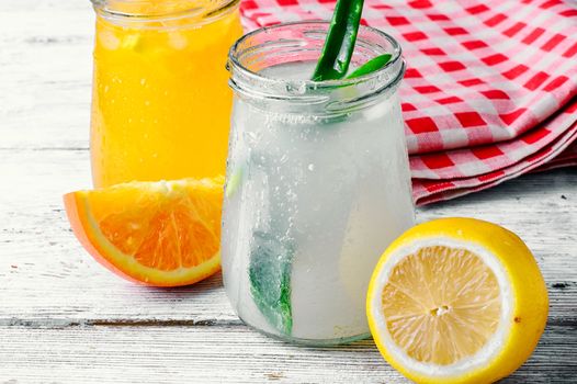 Three bottles of drinks from aloe,orange, and cranberries in a light tone