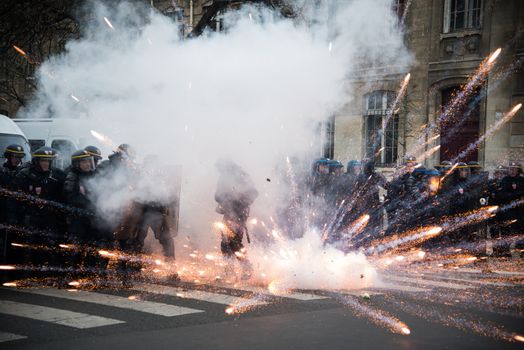 FRANCE, Paris: A firework exploses among riot policemen during a demo on April 9, 2016 in Paris, against the French government's proposed labour law reforms.