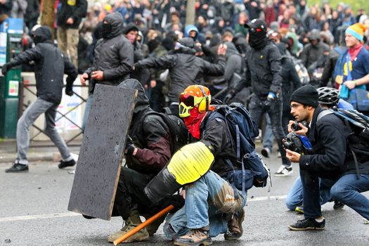 FRANCE, Paris: Protesters hide behind an homemade shield during a demo on April 9, 2016 in Paris, against the French government's proposed labour law reforms.