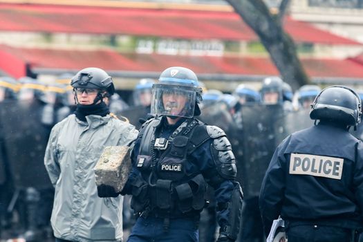 FRANCE, Paris: A riot policeman holds a cobblestone during a demo on April 9, 2016 in Paris, against the French government's proposed labour law reforms.