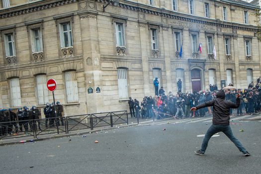 FRANCE, Paris: A protester throws an unidentifiable item to riot policemen during a demo on April 9, 2016 in Paris, against the French government's proposed labour law reforms.