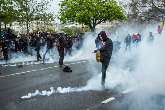 FRANCE, Paris: A protester shoots in a tear gas can during a demo on April 9, 2016 in Paris, against the French government's proposed labour law reforms.