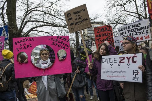 POLAND, Warsaw: People attend an anti-government and pro-abortion demonstration in front of parliament, on April 9, 2016 in Warsaw. The banner reads ' Sentenced to death by 'pro-life defenders'. 