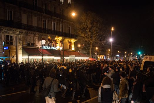 FRANCE, Paris: Nuit Debout militants stand in front of riot policemen on Boulevard Voltaire in Paris, as they want to reach French Prime minister Manuel Valls residence on April 9, 2016.