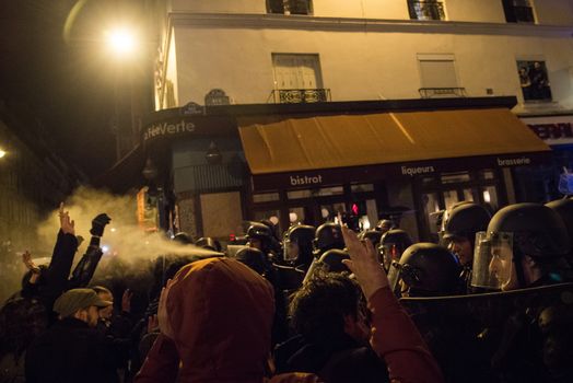 FRANCE, Paris: Riot policemen use tear gas to contain Nuit Debout militants in Rue de la Roquette in Paris, as they want to reach French Prime minister Manuel Valls residence on April 9, 2016.