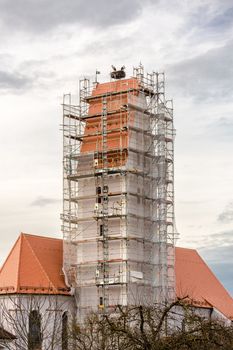 two storks in their nest above a scaffolded church spire