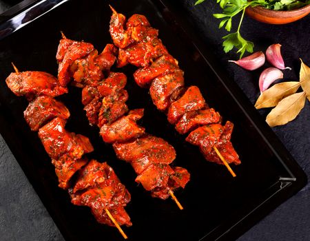 Still life beef skewers over black background