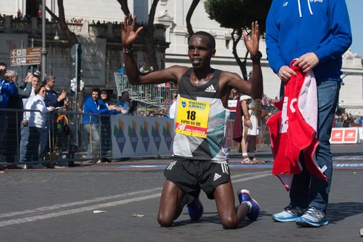 ITALY, Rome: Kenyan runner Amos Kipruto is pictured down on his knees as he won the finish line of Rome City Marathon  in Rome on April 10, 2016. He won the first position in 2h08'16”.