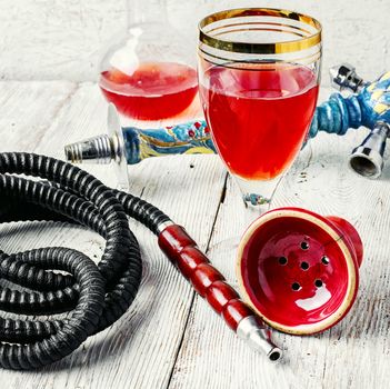 Details smoking Arab hookah and a glass of young wine pink