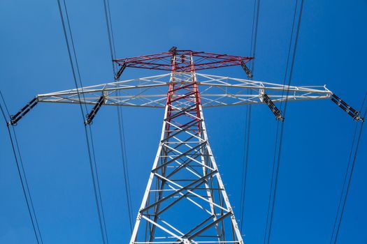 Detail of a new electricity tower, with blue sky in the background.