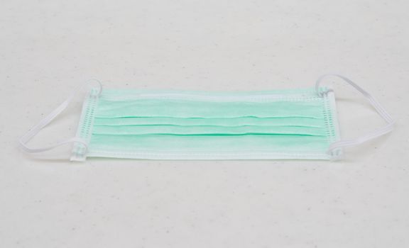 Green medical shielding bandage or mask placed on table at nurse station.