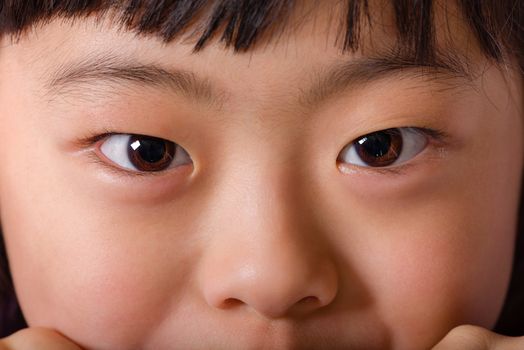 A close up macro shot of a young Japanese girl's face.