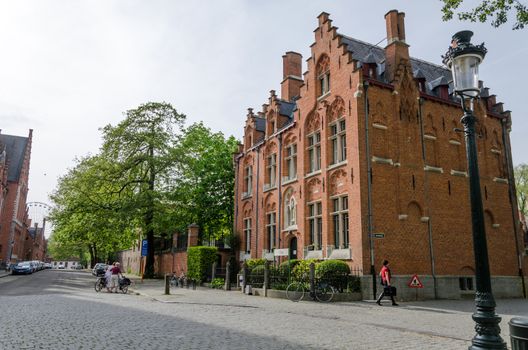 Bruges, Belgium - May 11, 2015: People around the Beguinage (Begijnhof) in Bruges, Belgium. Bruges is the capital and largest city of the province of West Flanders in the Flemish Region of Belgium.