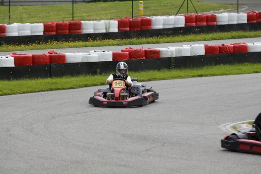 go-kart pilot is racing a race in an outdoor go karting circuit 