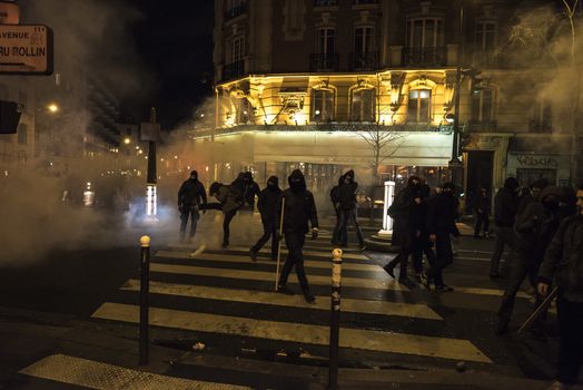 FRANCE, Paris: Riot policemen use tear gas to contain Nuit Debout militants in Avenue Ladru-Rollin in Paris, as they want to reach French Prime minister Manuel Valls residence on April 9, 2016. 