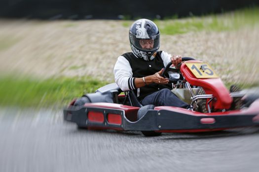 go-kart pilot is racing a race in an outdoor go karting circuit 