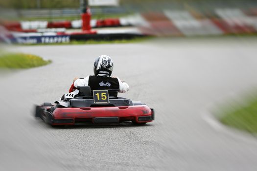 go-kart pilot is racing a race in an outdoor go karting circuit 