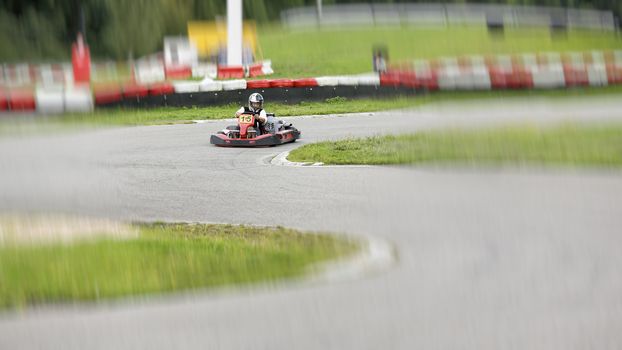 go-kart pilot is racing a race in an outdoor go karting circuit 