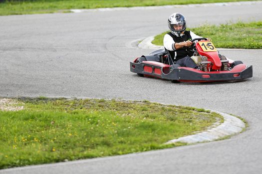 go-kart pilot is racing a race in an outdoor go karting circuit 