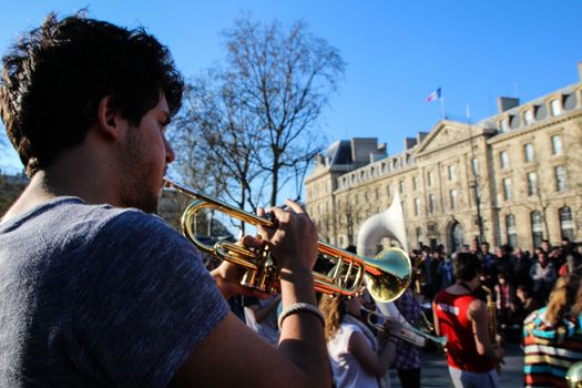 FRANCE, Paris: A man plays trumpet as thousand militants of the Nuit debout (Night Rising) movement gather on April 10, 2016 at the Place de la Republique in Paris, as participants plan to spend the night camped out to protest against the government's planned labour reform and against forced evictions. It has been one week that hundred of people have occupied the square to show, at first, their opposition to the labour reforms in the wake of the nationwide demonstration which took place on March 31, 2016.