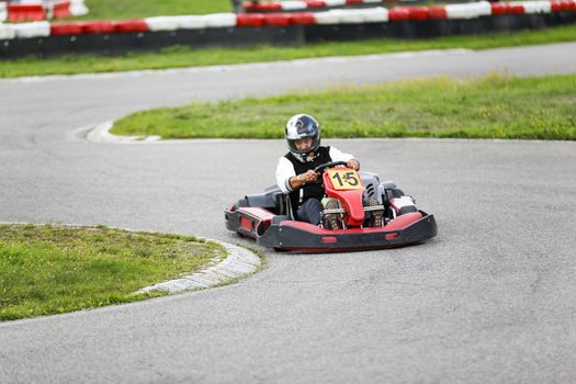 go-kart pilot is racing a race in an outdoor go karting circuit 