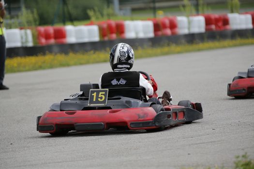 go-kart pilot is racing a race in an outdoor go karting circuit 