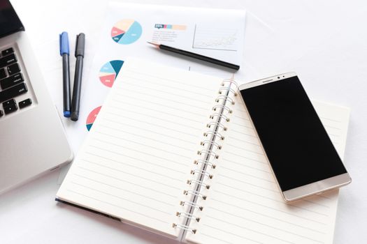 Blank note book with pencil pen laptop and smartphone on white table concept and Idea for write your text here.