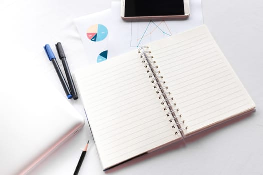 Blank note book with pencil pen laptop and smartphone on white table concept and Idea for write your text here.