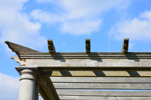 Edge of wooden pergola with sky in background