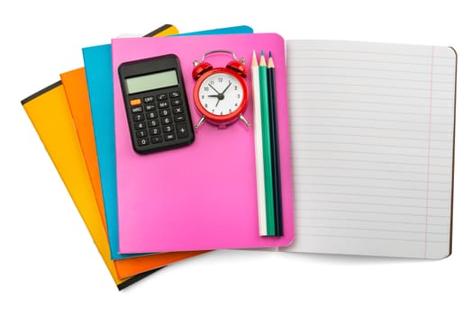 Open notebook with crayons, calculator and alarm clock on isolated white background, closeup