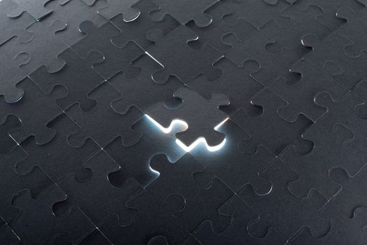 Grey puzzle background with flying piece, close up view