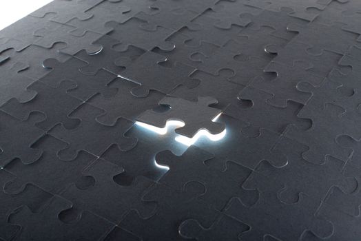 Grey puzzle background with flying piece and light