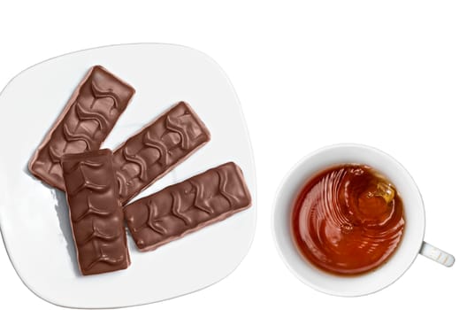 Tea in white Cup and chocolate in a white plate on a white background.