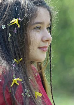 Beautiful girl with flowers in her hair in spring time