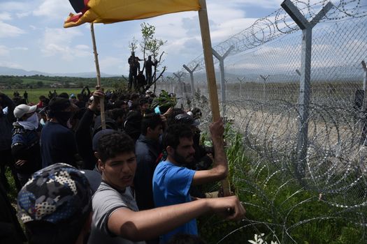 GREECE, Idomeni: Migrants gather at the border fence with Greece and Macedonia on April 11, 2016, a day after clashes between Macedonian security and the migrants attempting to cross the border.Hundreds of migrants were injured on Sunday as they attempted to cross the border into Macedonia. Police used tear gas, water cannons, and stun grenades to disperse the crowd as migrants threw stones in retaliation. 