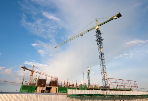 Industrial construction cranes on sky background