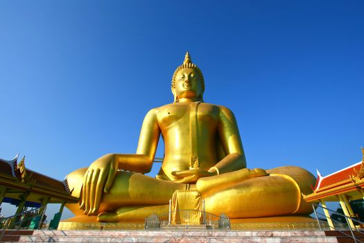 big golden Buddha statue with a blue sky, Thailand