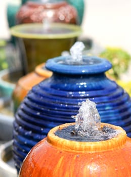 Orange jar fountain in garden