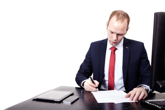 Businessman signs a contract in the workplace. On the table, computer, phone, tablet, mouse, keyboard. Isolated on white background