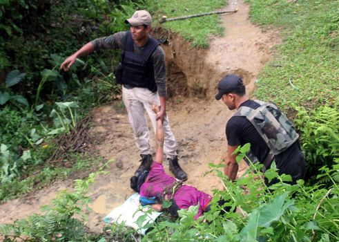 INDIA, Tinsukia: [WARNING: graphic content] Officers drag a woman's body after a protest where at least eleven people were killed, and twelve others injured, when a high-voltage electric cable was hit by stray police fire and fell on protesters in Tinsukia, Assam, India on April 11, 2016. Protesters had reportedly stormed a police station, calling on police to hand over a group of suspects arrested for killing two people last week. Police opened fire to disperse protesters, and a stray bullet severed the power line, which fell and electrocuted demonstrators.