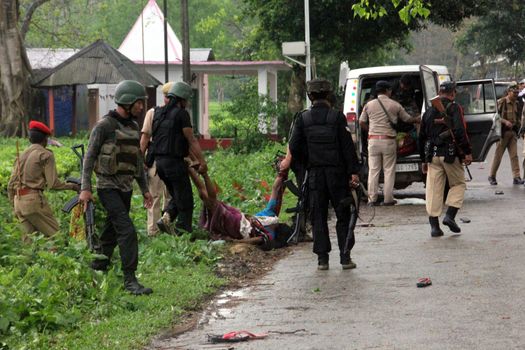 INDIA, Tinsukia: [WARNING: graphic content] Officers carry a woman's body after a protest where at least eleven people were killed, and twelve others injured, when a high-voltage electric cable was hit by stray police fire and fell on protesters in Tinsukia, Assam, India on April 11, 2016. Protesters had reportedly stormed a police station, calling on police to hand over a group of suspects arrested for killing two people last week. Police opened fire to disperse protesters, and a stray bullet severed the power line, which fell and electrocuted demonstrators.