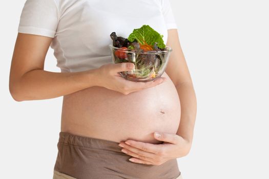 Pregnant woman's belly and vegetable salad. Healthy nutrition. isolated over white background