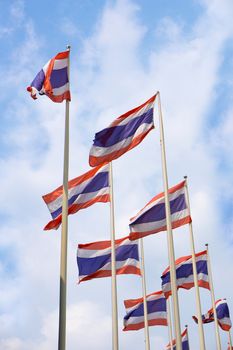 waving Thai flag of Thailand with blue sky background