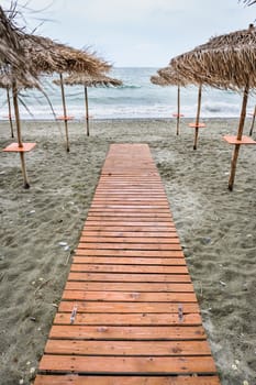 Wooden floor at the beach and dramatic overcast sky background