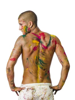 Handsome young man seen from the back with skin all painted with Holi colors, isolated on white background