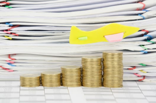 Airplane fly on step pile of gold coins on finance account  have stack overload document of receipt and report with colorful paperclip as background.